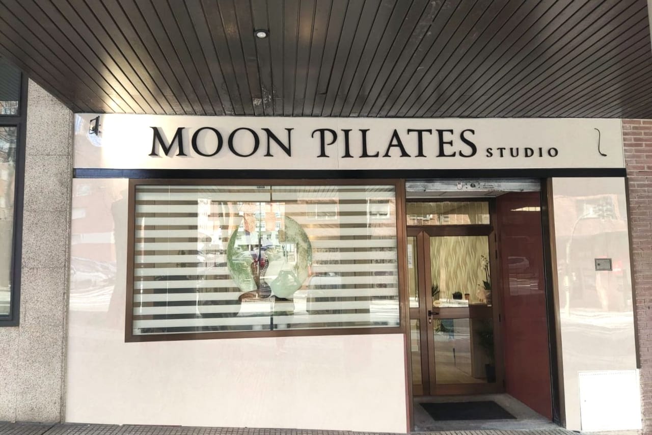 Fachada del estudio: rótulo «Moon Pilates Studio» sobre el escaparate y la puerta de entrada.