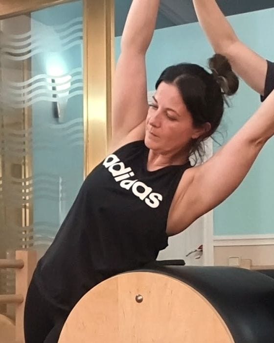 Mayte, fundadora y profesora del estudio, durante un estiramiento lateral sobre el barril.