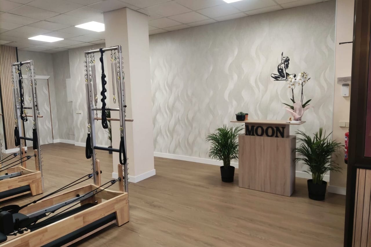 Recepción del estudio: el mostrador con el rótulo MOON, una orquídea y plantas.